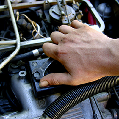 A person's hand working on an engine.