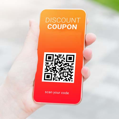 Hand holding smartphone displaying a mobile coupon with a QR code.