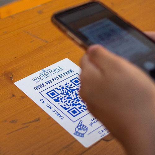 Person scanning a QR code with smartphone.